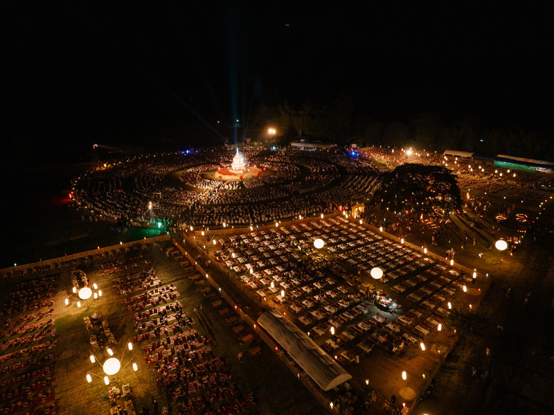 Night scene with candles and lights around a central monument during a festival at Yi Peng Chiang Mai.