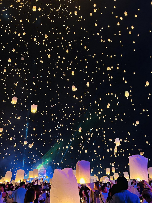People release sky lanterns into the night sky during a festival celebration at Yi Peng Chiang Mai.