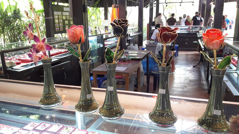 Flower Display in Shop at Chiang Mai Orchid Farms Glass vases with colorful artificial flowers inside a shop display counter at Chiang Mai Orchid Farms.