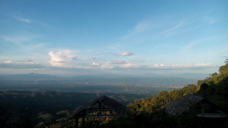 Expansive landscape with distant mountains and sky from a high viewpoint at Mon Jam.