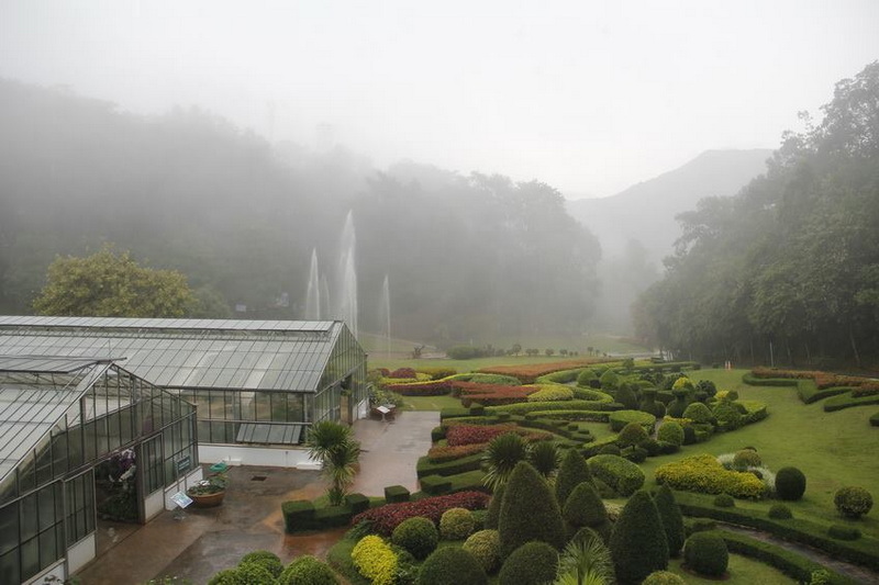 Misty Botanical Garden Scene at Queen Sirikit Botanic Garden Misty garden with greenhouses, fountains, and lush landscaping in a botanical setting at Queen Sirikit Botanic Garden.