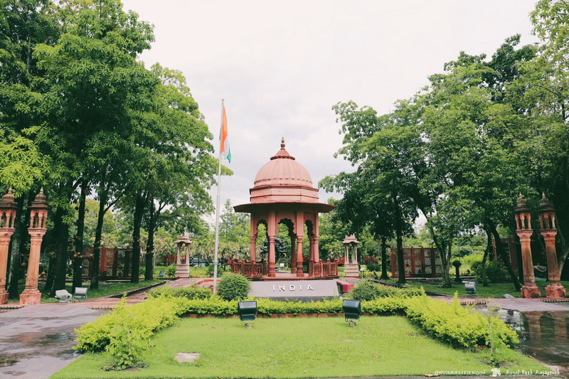 Pink Pavilion in Garden at Flower Park Chiang Mai Pink stone pavilion with green trees and an Indian flag in a garden setting at Flower Park Chiang Mai.