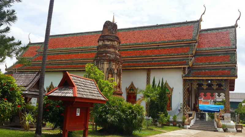 Thai Temple Architecture at Chamadevi Temple Traditional Thai temple with decorative roof and lush surroundings at Chamadevi Temple.