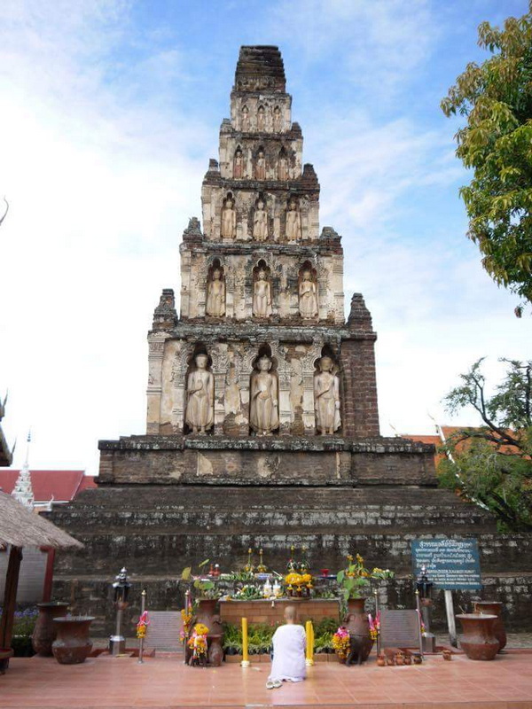 Ancient Buddha Pagoda at Wat Chamadevi Ancient brick pagoda with Buddha statues and offerings in front at Wat Chamadevi.