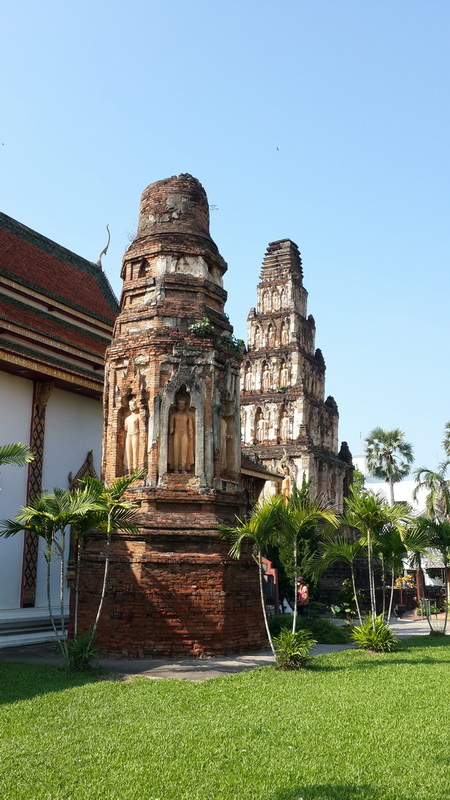 Ancient brick pagoda and temple architecture with greenery and potted plants nearby at Chamadevi Temple.