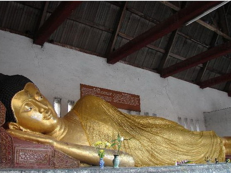 Reclining Buddha Inside Temple at Chedi Luang temple Golden reclining Buddha statue inside a simple temple room with a metal roof at Chedi Luang temple.