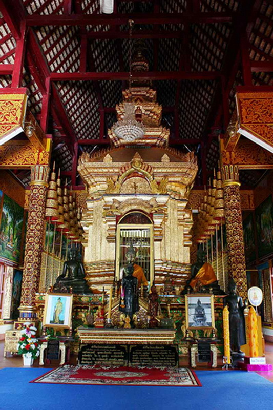 Temple Interior with Golden Decor at Wat Chiang Man Interior of a richly decorated temple with statues and ornate golden details at Wat Chiang Man.