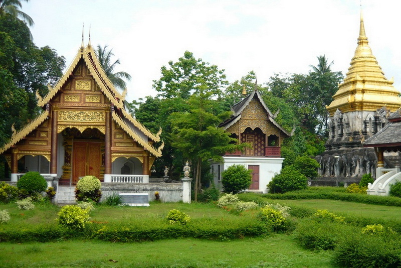 Thai Temples and Stupa at Wat Chiang Man Traditional Thai temples with golden stupa and lush garden scenery at Wat Chiang Man.