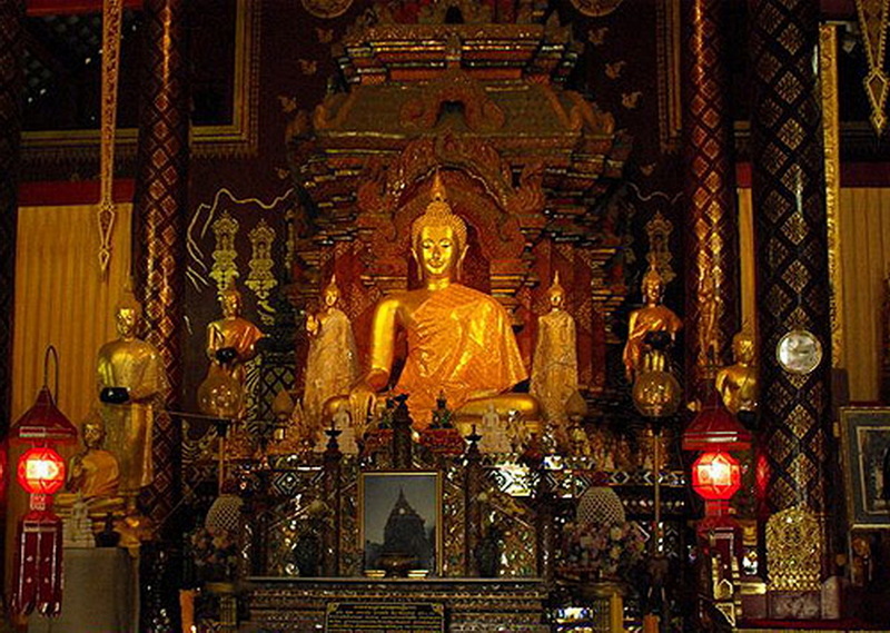 Golden Buddha in Temple Interior at Wat Chiang Man Golden Buddha statue inside a decorated temple with smaller statues and detailed ornaments at Wat Chiang Man.