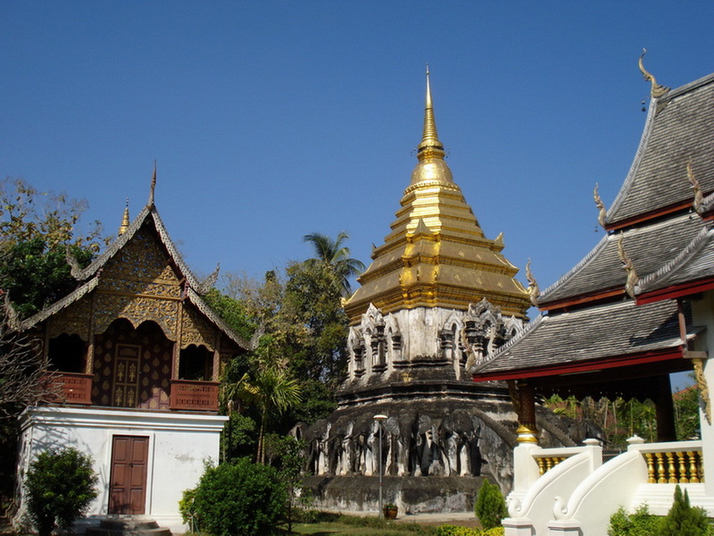 Thai Temple with Golden Pagoda at Wat Chiang Man Golden pagoda with tiered spire and traditional Thai-style buildings around it at Wat Chiang Man.