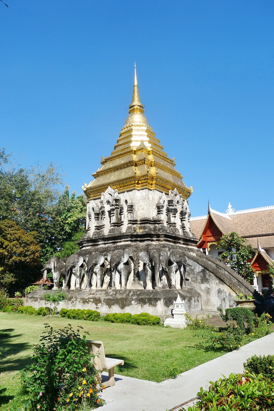 Golden Pagoda with Elephant Bas-Reliefs at Wat Chiang Man Golden pagoda with elephant statues at its base and a clear blue sky above at Wat Chiang Man.