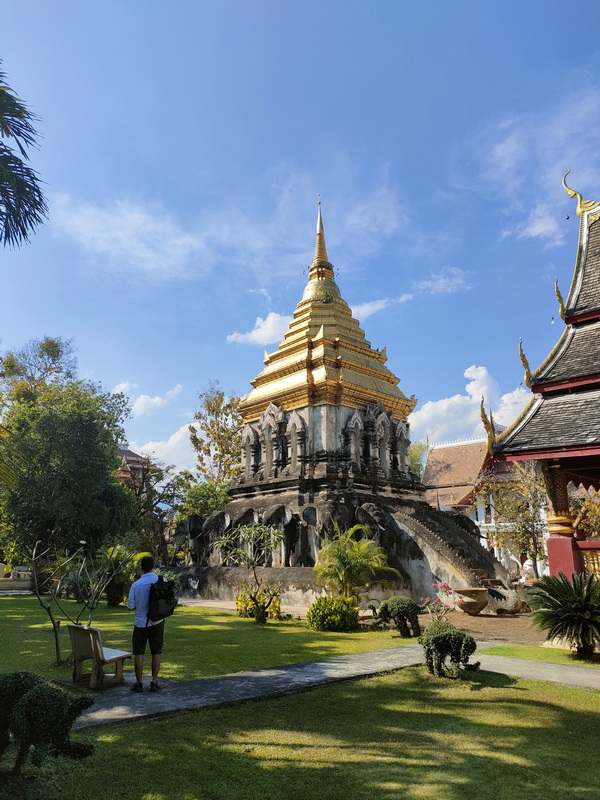 Golden Stupa in a Temple Garden at Wat Chiang Man Golden stupa with stairs and surrounding greenery under a bright blue sky at Wat Chiang Man.