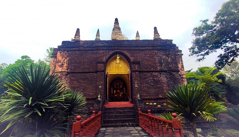 Brick Temple with Spires at Wat Jed Yod Ancient brick temple with spires and lush surrounding greenery at Wat Jed Yod.