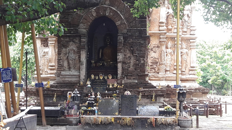 Buddhist Shrine with Statues at Wat Jed Yod Brick Buddhist shrine with statues and offerings surrounded by trees at Wat Jed Yod.