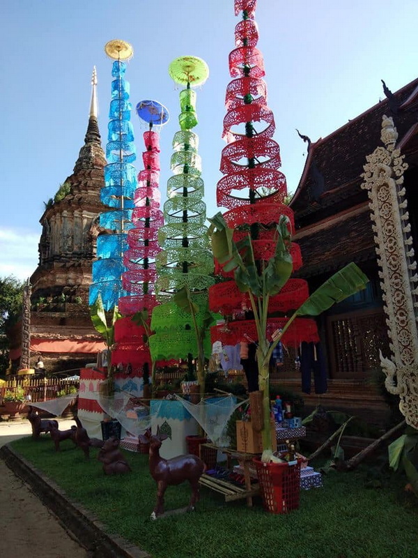 Colorful paper lanterns hanging in front of a historic temple with ornate woodwork at Wat Lok Moli.