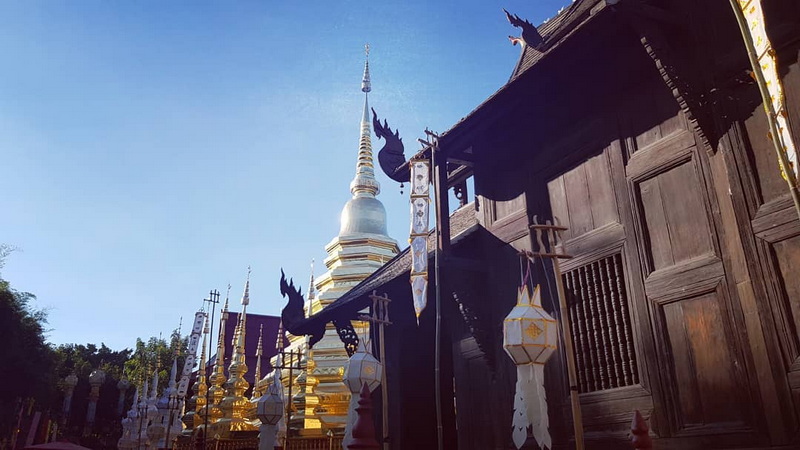 Traditional Temple with Golden Stupa at Phan Tao Temple Wooden temple with decorative finials and a tall golden spire in the background at Phan Tao Temple.