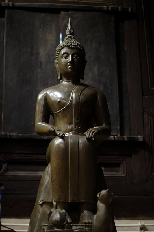 Bronze Buddha Statue at Phan Tao Temple Bronze Buddha statue with serene expression inside a wooden room at Phan Tao Temple.