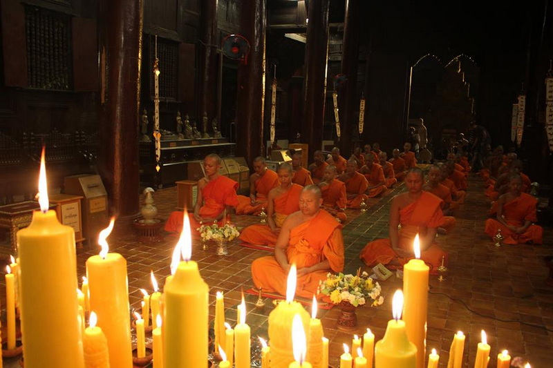 Monks Meditation in Temple at Wat Phan Tao Monks meditating inside a temple with candles in the foreground at Wat Phan Tao.