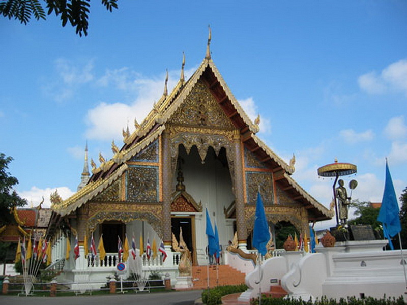 Decorative Temple Exterior at Wat Phra Singh A richly decorated temple with elaborate roof and gold accents under a clear blue sky at Wat Phra Singh.