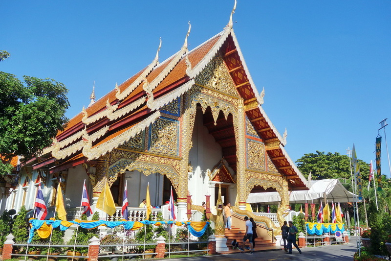Traditional Thai Temple Architecture at Wat Phra Singh Thai temple with intricate gold details and colorful decorations under a bright sky at Wat Phra Singh.