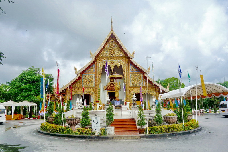 Thai Temple with Gold Decorations at Wat Phra Singh Colorful Thai temple with gold decorations and surrounding flags and greenery at Wat Phra Singh.