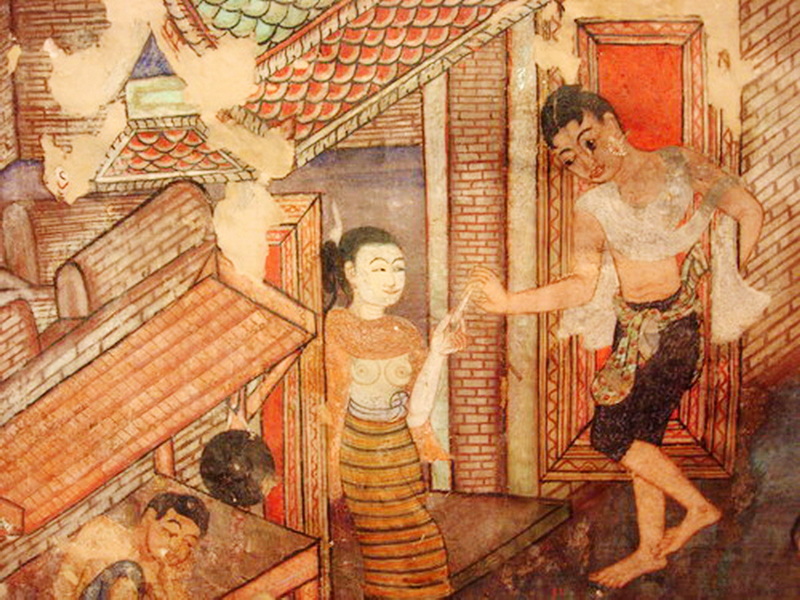 Traditional Mural Scene at Wat Phra Singh Colorful mural showing a woman holding a drink and a man dancing on a brick wall at Wat Phra Singh.