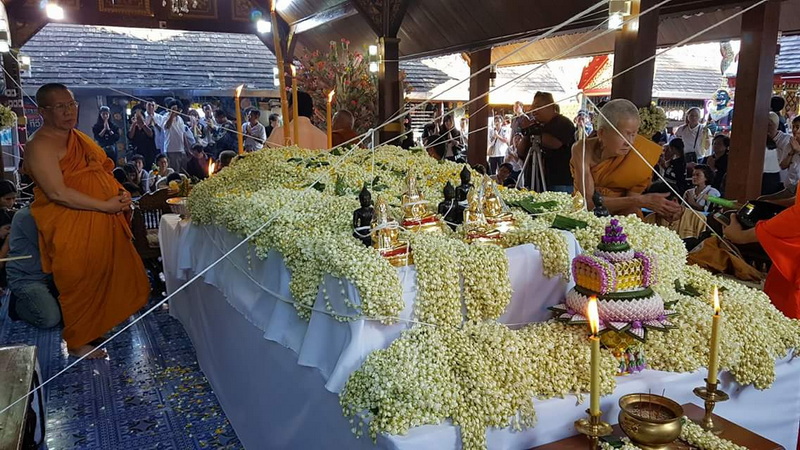 Temple Ceremony with Floral Offerings at Wat Phra That Doi Kham Monks and worshipers participating in a ceremony with floral decorations inside a temple at Wat Phra That Doi Kham.