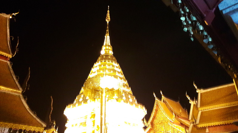 Illuminated Golden Stupa at Night at Wat Phra That Doi Suthep Brightly illuminated golden stupa with ornate Thai temple roofs at night at Wat Phra That Doi Suthep.