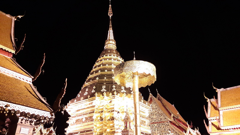 Golden Stupa at Night at Doi Suthep temple Night view of a golden illuminated stupa with traditional Thai rooftops surrounding it at Doi Suthep temple.