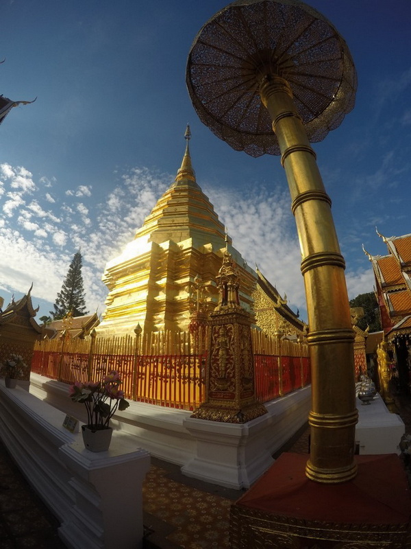 Wat Phra That Doi Suthep Stupa at Doi Suthep temple Golden stupa with decorative fencing and large umbrella structure under a blue sky at Doi Suthep temple.