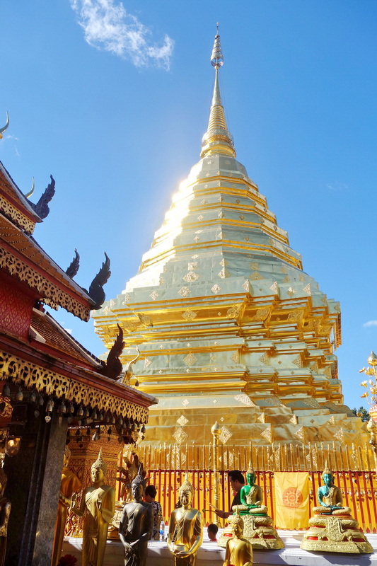Golden Stupa in Clear Sky at Doi Suthep temple Golden stupa with spire under blue sky, surrounded by temple statues and intricate details at Doi Suthep temple.