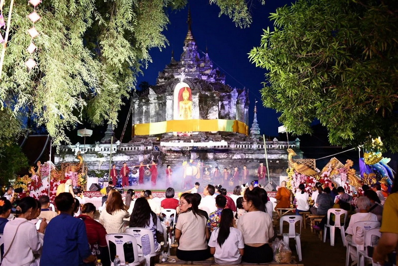 Nighttime Ceremony at Stupa at Wat Phra Yuen Gathering of people in front of a lit stupa during a nighttime ceremony with trees around at Wat Phra Yuen.