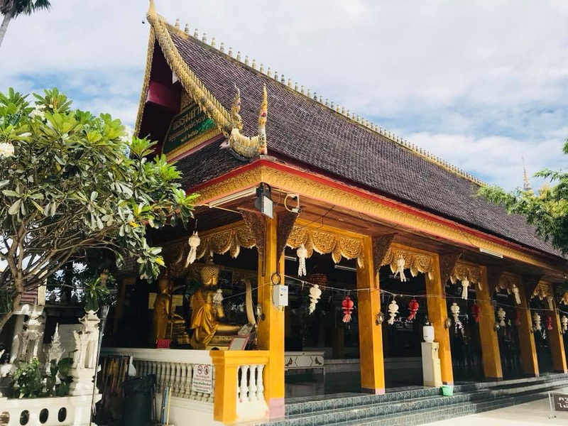 Thai Temple with Gold Decorations at Wat San Pa Yang Luang Traditional Thai temple with ornate roof and gold decorations surrounded by greenery at Wat San Pa Yang Luang.