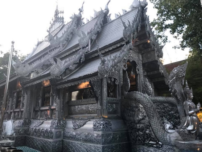 Silver temple with intricate dragon sculptures and detailed carvings at Wat Sri Suphan.