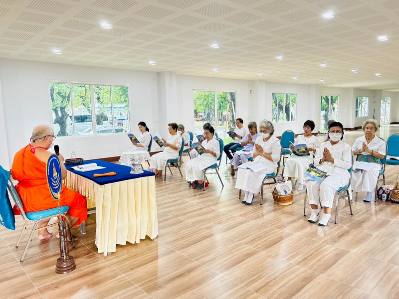 Elderly women listening to a monk during an indoor religious event at Wat Suan Dok.