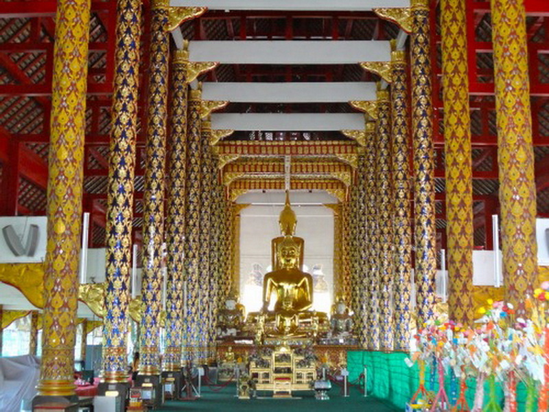 Temple Interior with Buddha Statue at Wat Suan Dok Golden Buddha statue inside a richly decorated temple with colorful pillars and patterns at Wat Suan Dok.