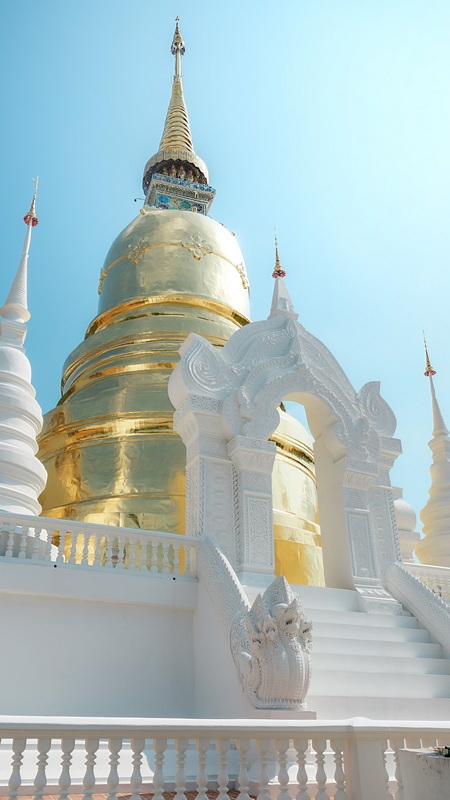Golden Stupa with White Entrance at Wat Suan Dok Golden stupa with elaborate white entrance and blue sky background at Wat Suan Dok.