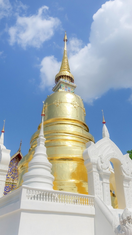 Golden Stupa Skyward View at Suan Dok Temple Golden stupa with spire under a partly cloudy sky at Suan Dok Temple.