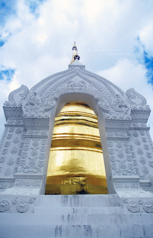 White Ornate Temple Structure at Suan Dok Temple White temple with golden bell-shaped ornament against a blue sky with clouds at Suan Dok Temple.