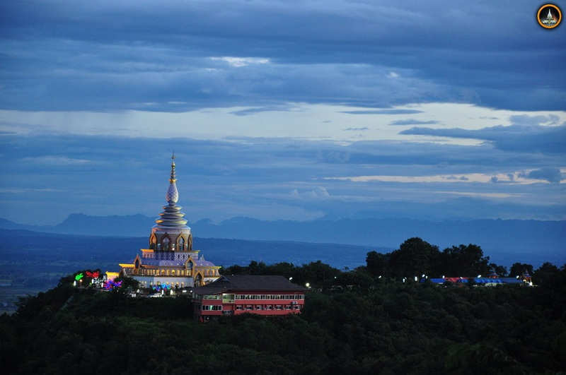 Pagoda with Mountain Views at Wat Thaton A decorated pagoda on a hill with a double-decker train below and mountain views in the background at Wat Thaton.