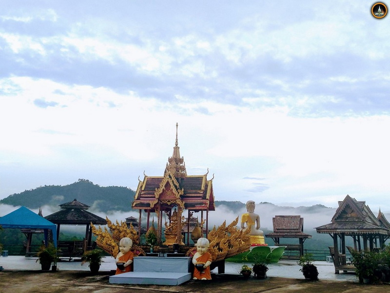 Thai Shrine with Mountain View at Wat Thaton Gold ornate Thai-style shrine with statues set against misty mountains and cloudy sky at Wat Thaton.