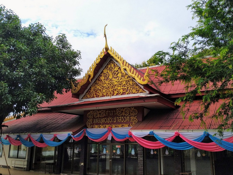 Traditional Thai Temple Exterior at Wat Thaton Thai temple with ornate golden decorations, red roof, and colorful drapes at Wat Thaton.