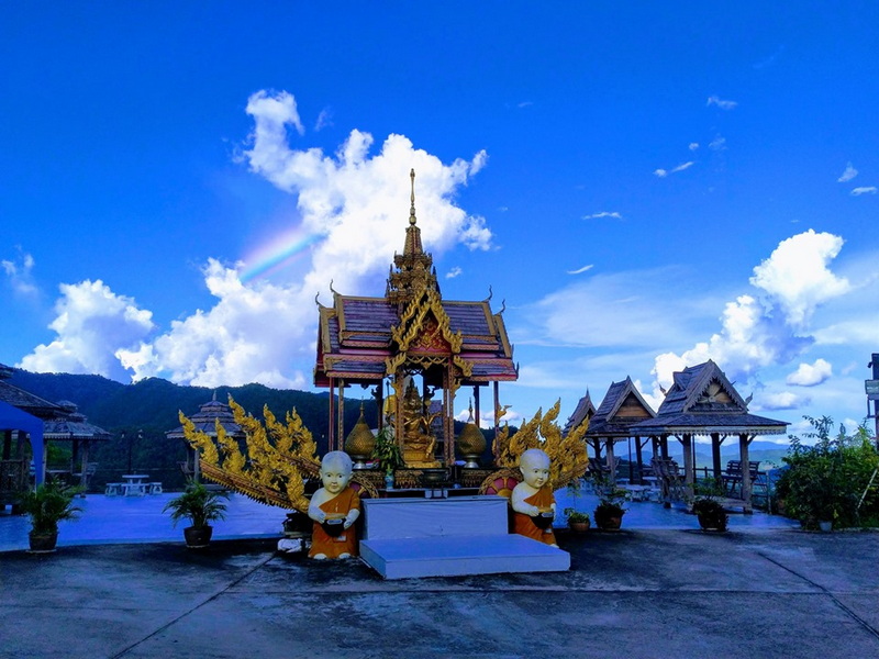 Ornate Shrine Under Blue Sky at Wat Thaton Small golden shrine with child statues and potted plants under blue sky at Wat Thaton.