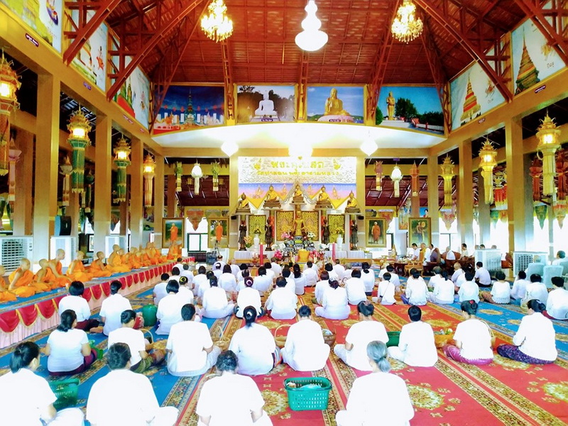 Inside temple with monks and worshippers during a religious ceremony at Tha Ton Temple.