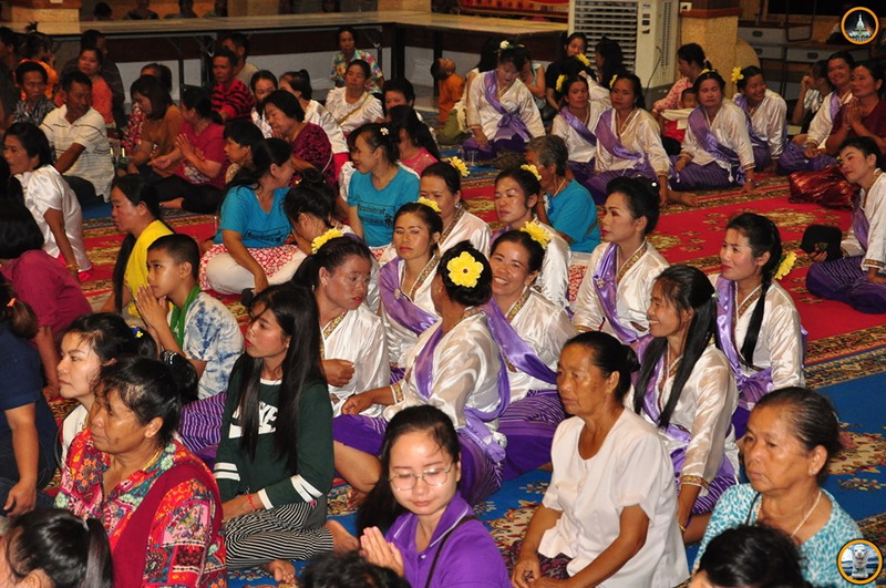 Community Gathering of Women and Children at Wat Thaton Group of women and children sitting on carpets during a cultural event indoors at Wat Thaton.