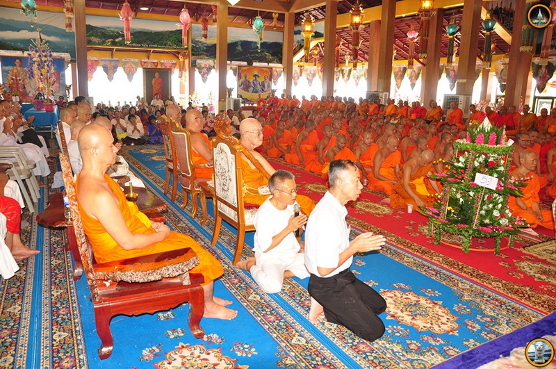 Monks and people participating in a religious ceremony inside a decorated hall at Tha Ton Temple.
