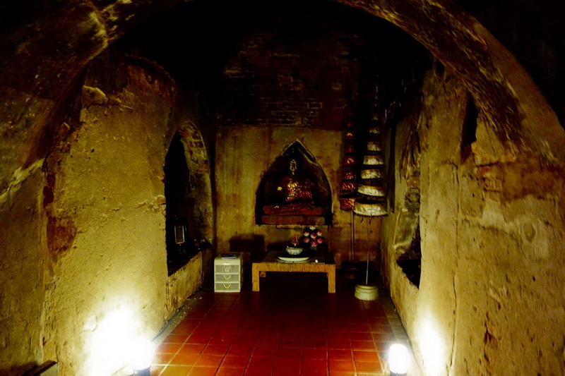 Underground temple chamber with Buddha statue and stone arches at Umong Temple.