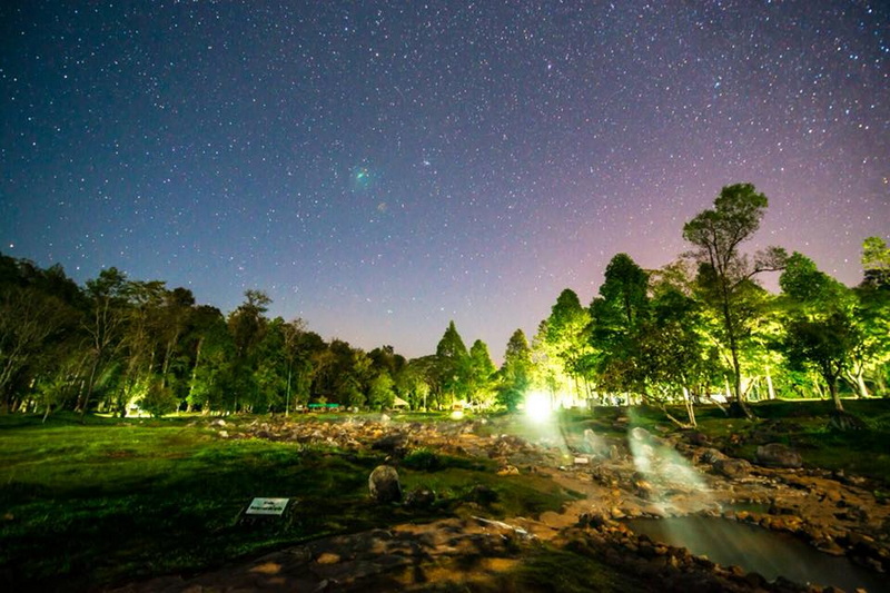 Night Sky Over Forest at Chae Son National Park Starry night sky over a forest with green-lit trees and a small stream at Chae Son National Park.