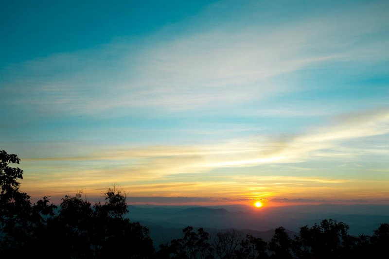 Sunset Over Mountain Horizon at Doi Khun Tan National Par Sunset scene with mountains, trees, and colorful sky at dusk at Doi Khun Tan National Par.