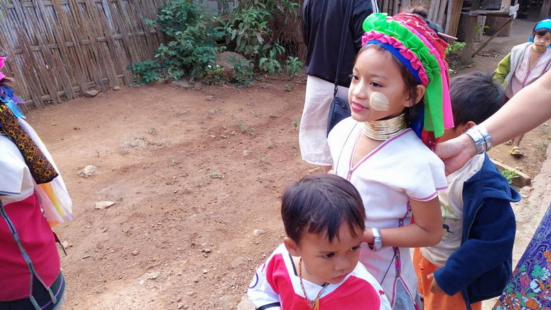 Children in Traditional Dress at Ban Nam Phiang Din Children with face paint and traditional clothing standing outdoors near a wooden fence at Ban Nam Phiang Din.